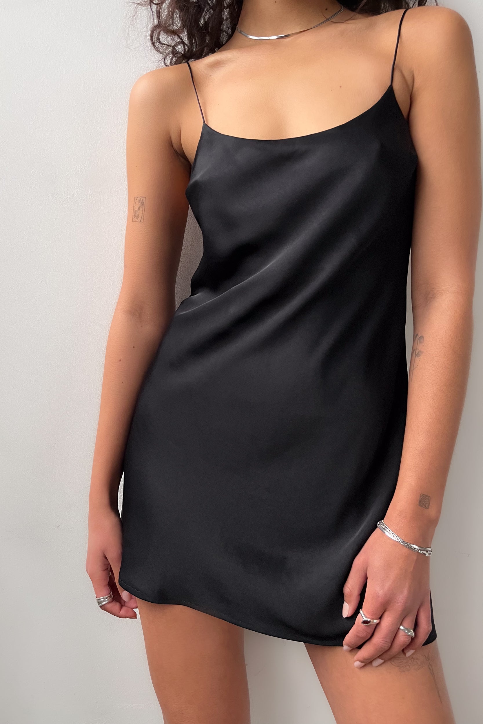 Close-up front view of the Backless Short Slip Dress in Black, showcasing its smooth satin texture and minimalist design.