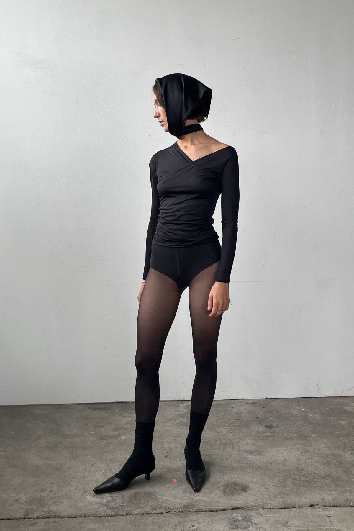 Full body front view of the Asymmetric V-Neck Long Sleeve Top in black, crafted from a soft, eco-conscious Micromodal.