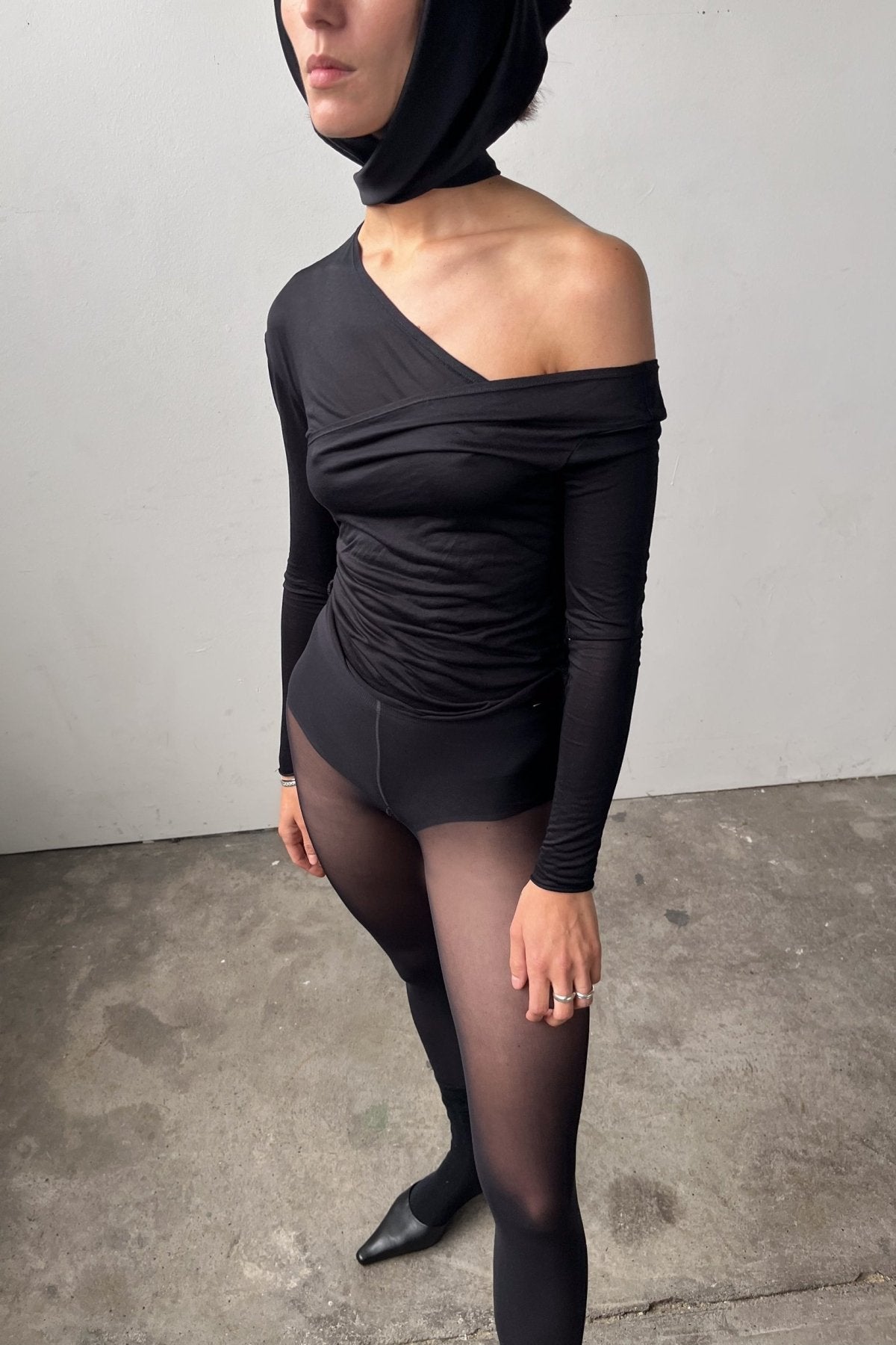Rear front view of the Asymmetric V-Neck Long Sleeve Top in black, crafted from a soft, eco-conscious Micromodal.