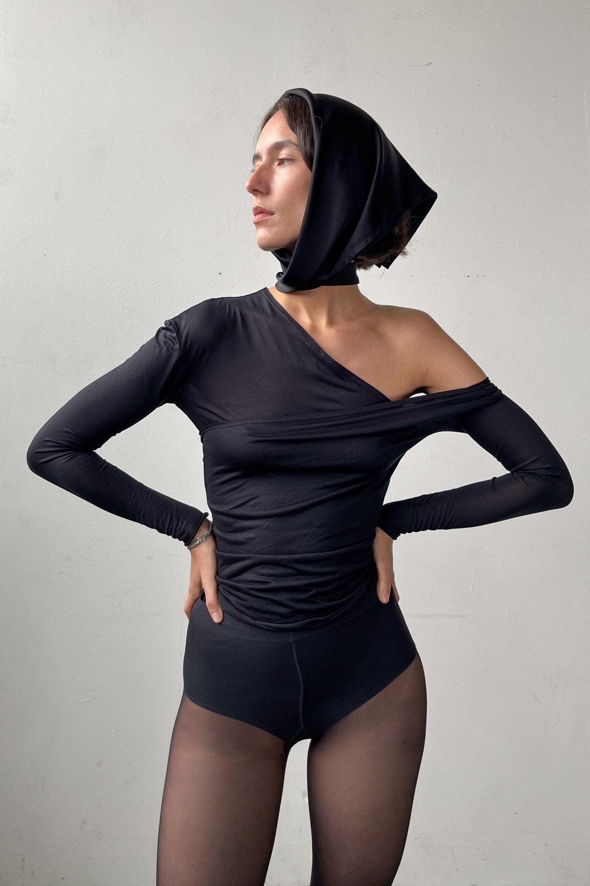 Front pose of the Asymmetric V-Neck Long Sleeve Top in black, crafted from a soft, eco-conscious Micromodal.