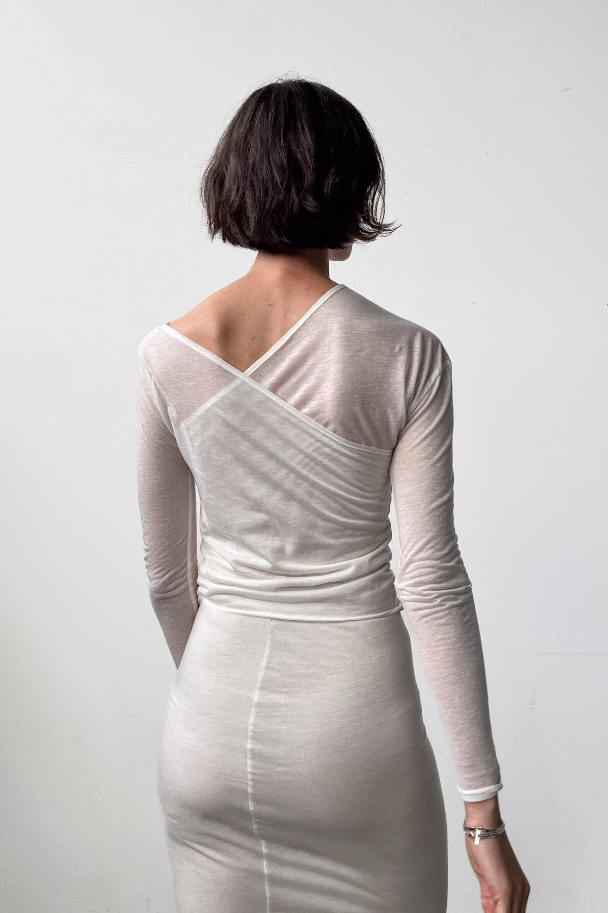 Close-up back view of the Asymmetric V-Neck Long Sleeve Top in Off White, crafted from a soft blend of recycled wool and modal.