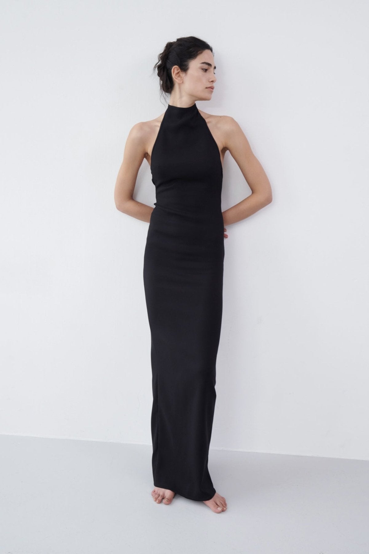 Front view of a black halter maxi dress featuring a high neckline, body-hugging fit, and elegant floor-length cut.