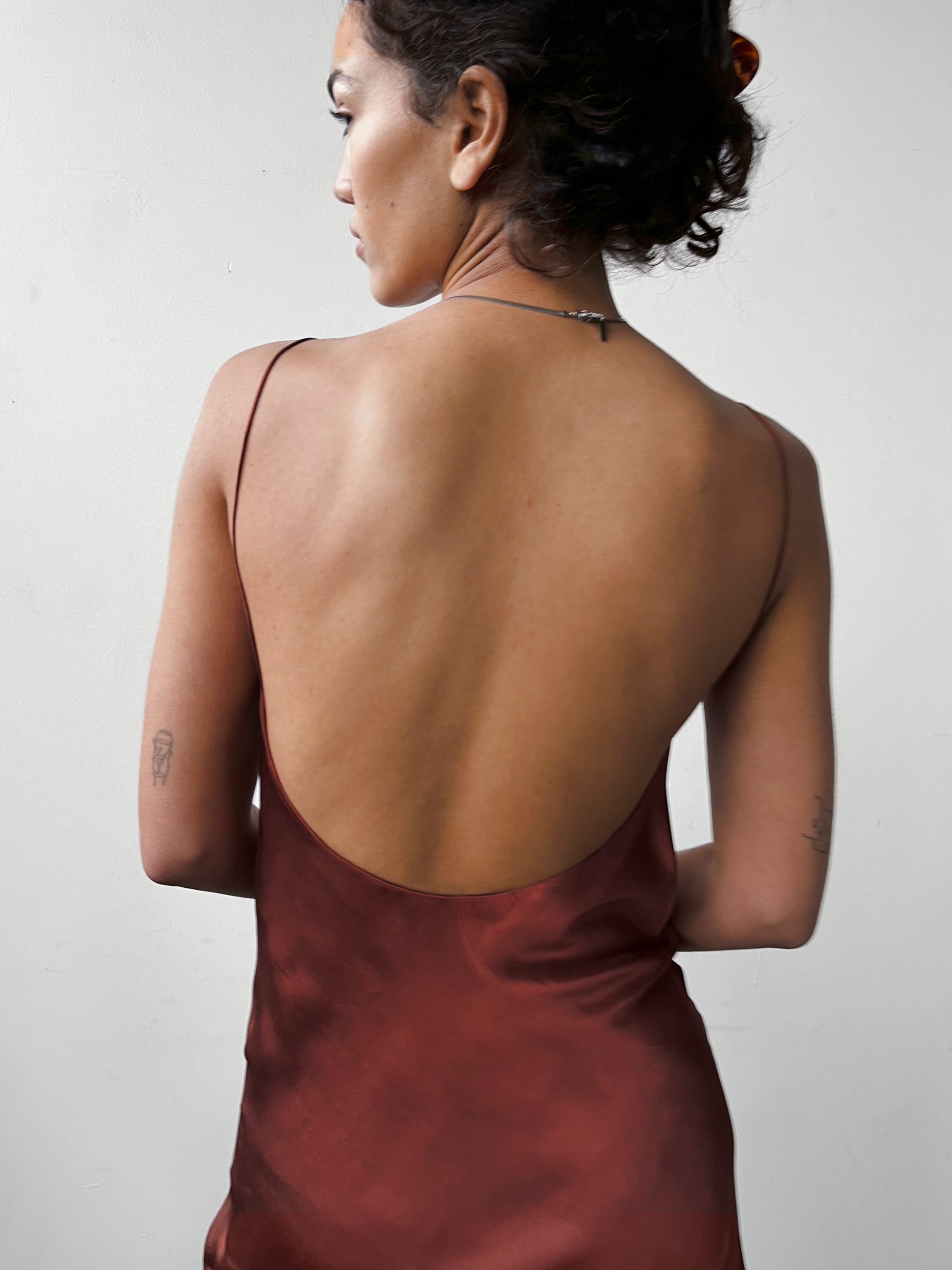 Close-up back view of the Backless Short Slip Dress in Red, showcasing its smooth satin and minimalist design.