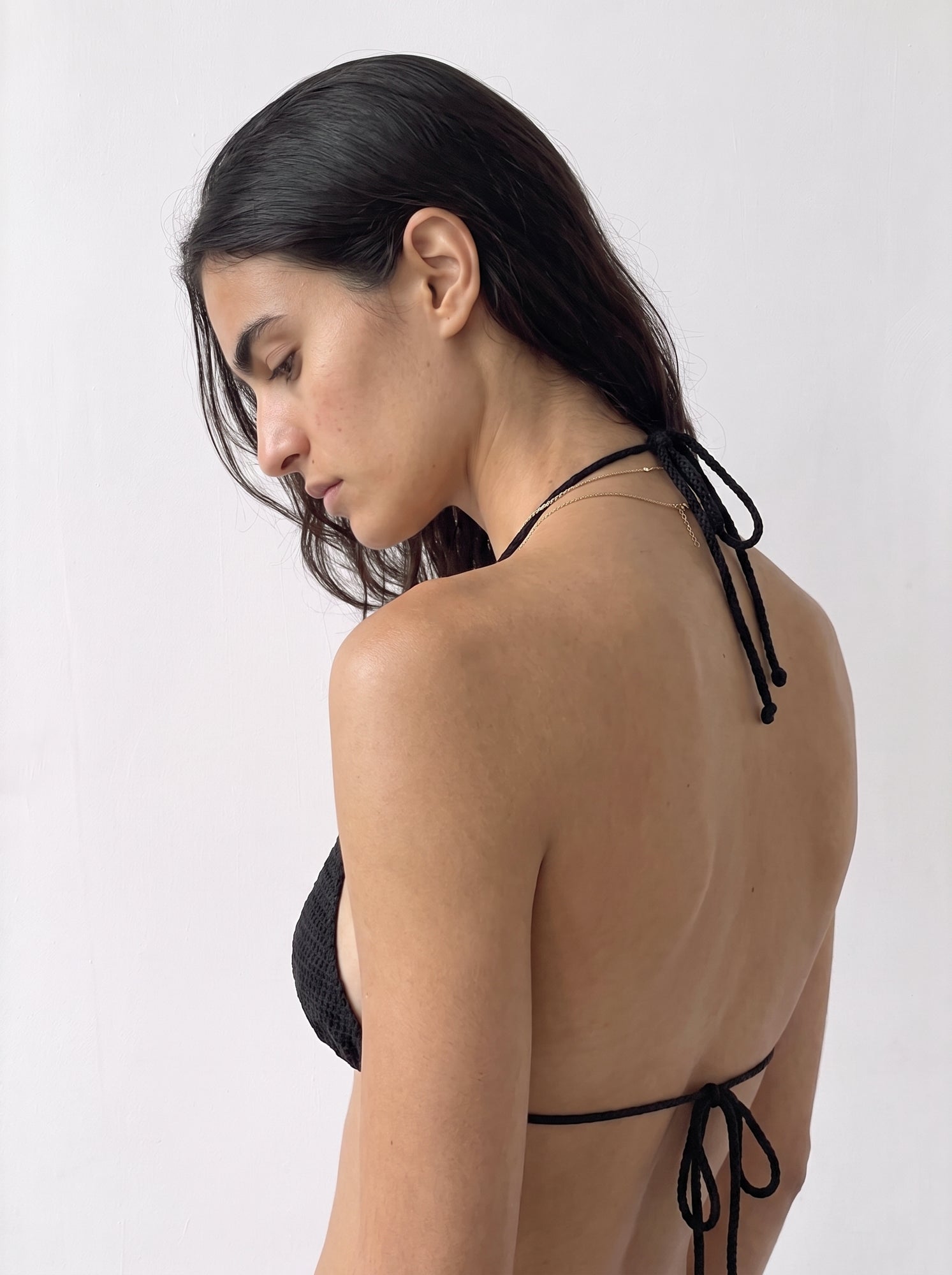 Back view of the black crochet bikini top showing the neck and back ties