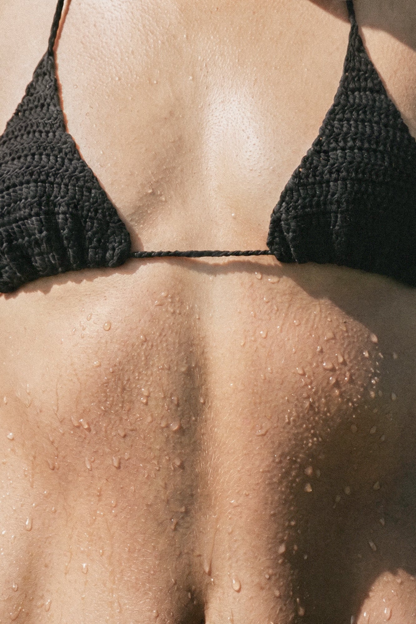 Front close-up of the handmade black crochet triangle bikini top with halter ties