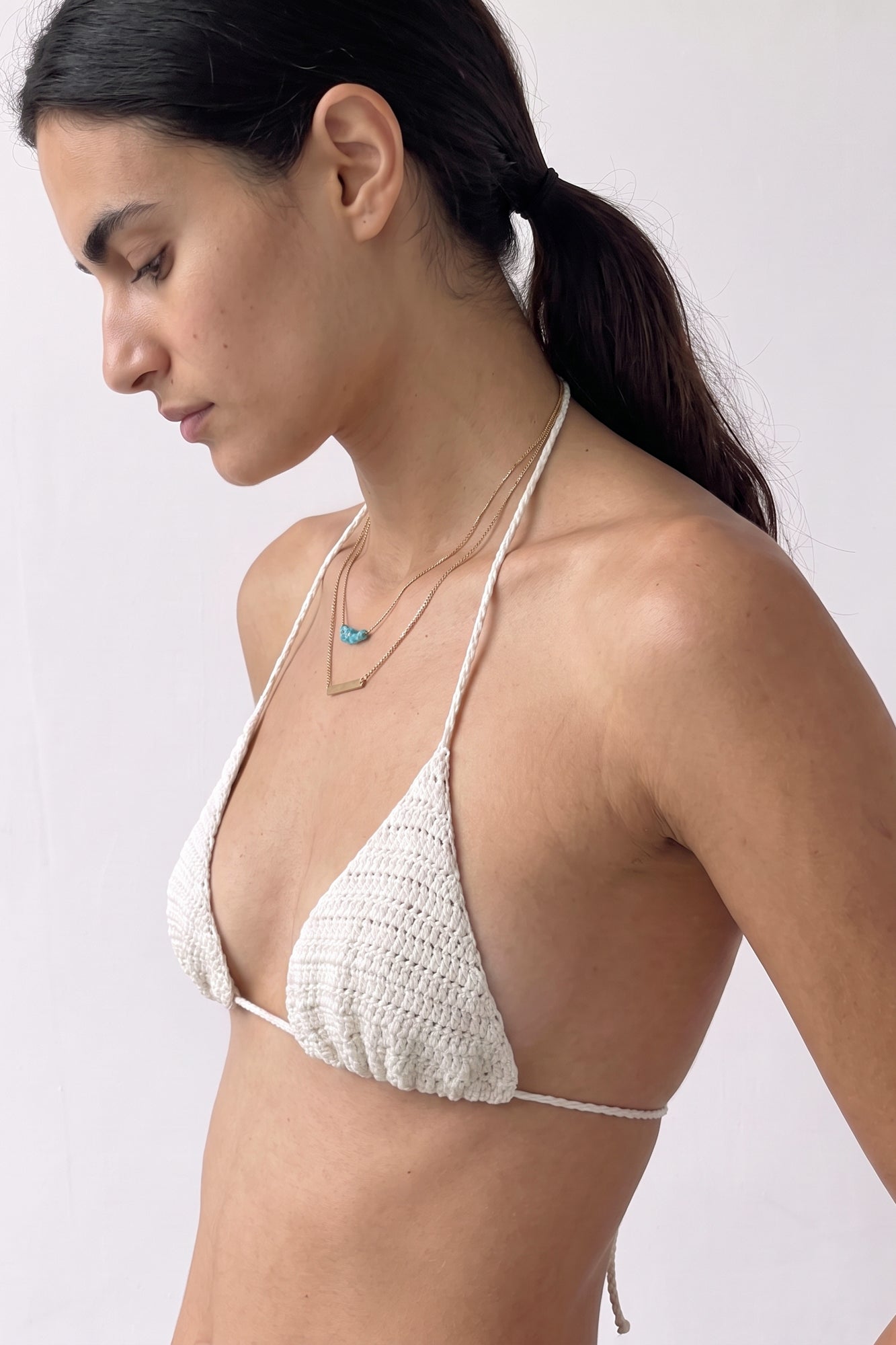 Side view of a model wearing the handmade cream crochet triangle bikini top