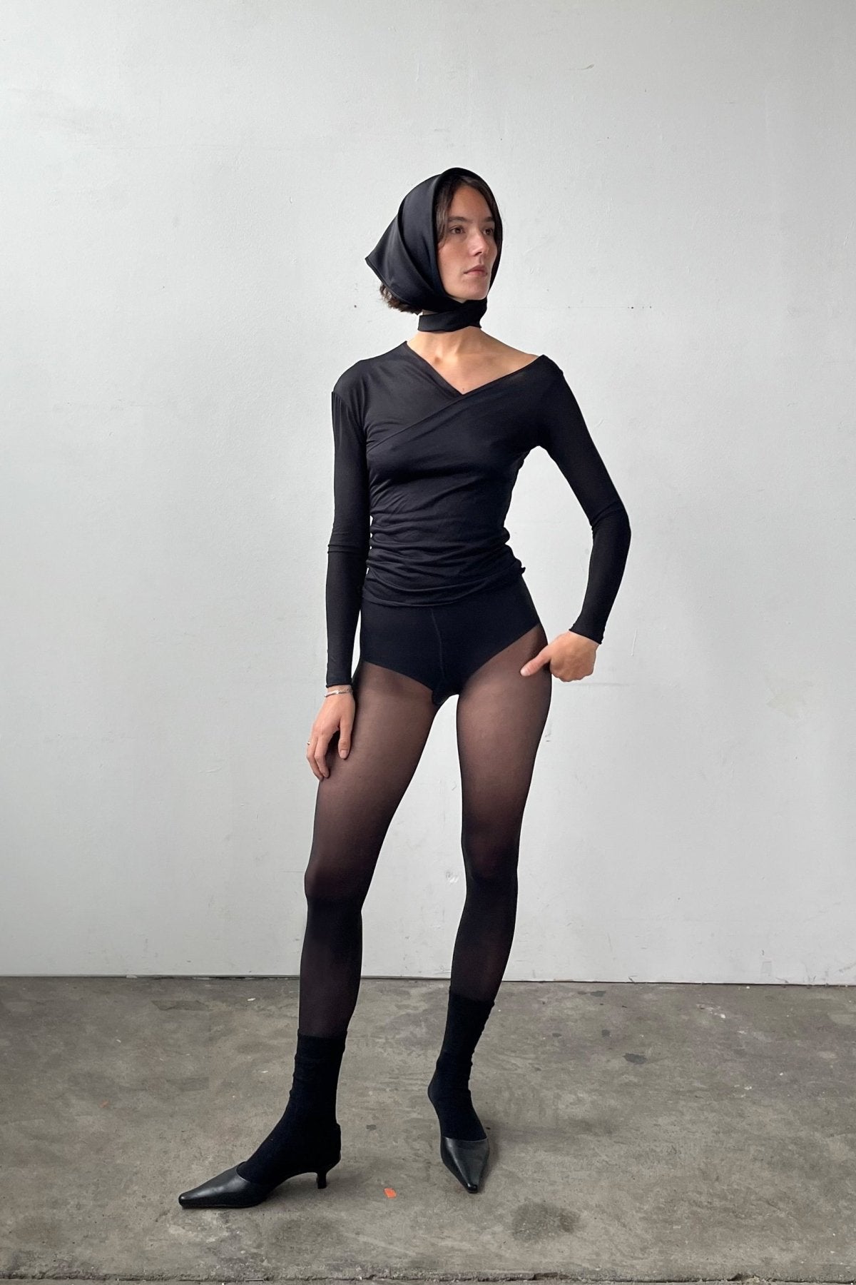 Full body front view of the Asymmetric V-Neck Long Sleeve Top in black, crafted from a soft, eco-conscious Micromodal.